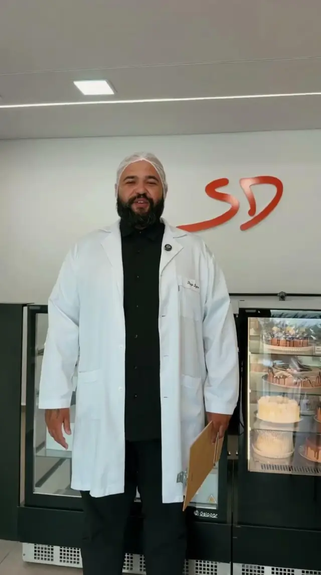 Nutricionista da Sabor em Dobro na loja, em frente às vitrines de bolos